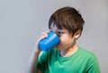 Side view portrait Kid drinking orange juice from plastic glass, Healthy young boy drinking glass of mixed fruits juice Royalty Free Stock Photo