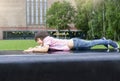 Side view portrait of little boy playing with toy lying down on bench in the park, Kid having fun playing outdoor. Child relaxing Royalty Free Stock Photo