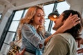 Side view portrait of a loving young couple embracing at home. Christmas lights background. Bottom view Royalty Free Stock Photo