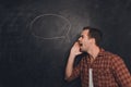 Side view portrait of man making announcement on the background of chalkboard Royalty Free Stock Photo