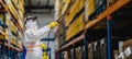 Man worker with protective mask and suit disinfecting industrial factory with spray gun.