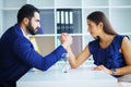 Side view portrait of man and woman armwrestling, exerting press