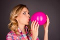 Side view portrait of pretty woman blowing balloon