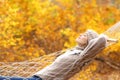 Relaxed woman lying on hammock in autumn forest Royalty Free Stock Photo