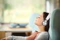 Relaxed woman with headphones listening to music on a sofa Royalty Free Stock Photo