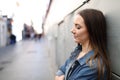 Sad girl complaining leaning on a wall in a solitary street