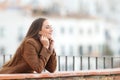 Satisfied woman heating in winter closing eyes in a balcony