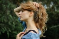 Side view portrait of sexy blonde girl with curly hair wearing blue casual jeans blouse and black lingerie posing in the Royalty Free Stock Photo