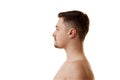 Side view portrait of shirtless young man with brunette hair and stubble posing half-naked against white studio Royalty Free Stock Photo