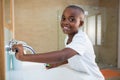 Side view portrait of smiling boy with toothbrush looking at mirror Royalty Free Stock Photo