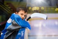 Young hockey player standing behind rink boards Royalty Free Stock Photo