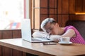 Side view portrait of tired kind beautiful young bussineswoman with blonde short hair in pink t-shirt and eyeglasses is sitting in