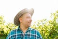 side view of portrait of a winemaker with a hat standing in vineyards