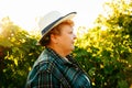 side view of a portrait of winemaker woman with hat looking at camera at sunset