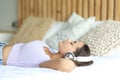 Woman relaxing listening music on a bed Royalty Free Stock Photo