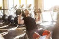 Side view portrait of young adult sport man training at gym alone. Athlete workout in gym, sitting and holding two dumbbell with Royalty Free Stock Photo