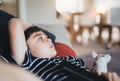 Side view portrait young boy sitting on sofa watching TV, Positive Kid lying on couch with dog toy in living room. Child relaxing Royalty Free Stock Photo