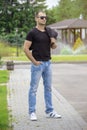 Side view portrait of a young fashion man wearing sunglasses and holding jacket on his shoulder on the street Royalty Free Stock Photo