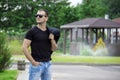 Side view portrait of a young fashion man wearing sunglasses and holding jacket on his shoulder on the street Royalty Free Stock Photo