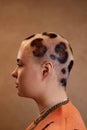 Side view portrait of young woman with buzzcut cheetah print