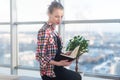 Side view portrait of young woman sitting, looking down, reading the book, learning at light room in morning with her Royalty Free Stock Photo