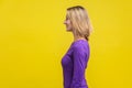 Side view of positive successful woman looking happy and content, empty copy space. on yellow background