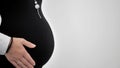 Side view of a pregnant woman holding her hand on her tummy. Isolated on white background. Royalty Free Stock Photo