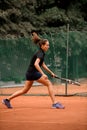 Side view of pretty woman player with tennis racket playing at outdoor tennis court. Royalty Free Stock Photo