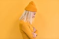 Side view of pretty blonde hair woman wears yellow clothes, hat, posing on yellow studio background. Copy space for advertisement Royalty Free Stock Photo
