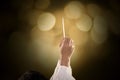 Priest hands raise a sacramental wafer with light