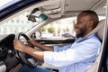 Smiling black guy driving new car in city Royalty Free Stock Photo