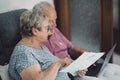 SIde view of real senior couple at home paying bills online with internet banking app and account. Concept of life costs and gas Royalty Free Stock Photo