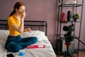 Side view of red-haired young woman recording cosmetics product review, applying powder, filming video for channel using Royalty Free Stock Photo