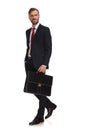 Side view of relaxed businessman with suitcase walking to work