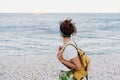 Side view of relaxed caucasian woman with yellow backpack walking by the beach during sunset. summer time. daydreaming. Outdoors Royalty Free Stock Photo