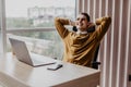 Side view of a relaxed young businessman sitting with hands behind head in the office Royalty Free Stock Photo