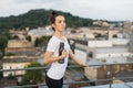 Female athlete holding sports bottle near roof handrails