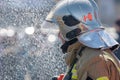 Side view of rescuer in silver mirrored helmet and protective uniform, water drops falling on firefighter Emercom of