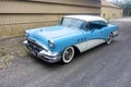 Side on view of a restored classic 1955 blue Buick sedan car