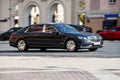 Side view rolling shot with black car in motion. Mercedes Maybach S Class driving along the street in city with blurred background Royalty Free Stock Photo