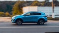 Side view rolling shot with blue Kia Sportage in motion. 4th generation QL series driving along country lane with blurred Royalty Free Stock Photo