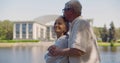 Side view of romantic mature couple embracing in park near lake Royalty Free Stock Photo