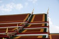 Side view of the roof of the Royal temple in Bangkok with blue and white sky