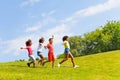 Side view of running kids group in the park lawn Royalty Free Stock Photo