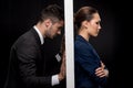 Side view of sad couple in formal wear separated by wall Royalty Free Stock Photo