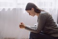 Side view of sad lonely young caucasian woman sits on sofa alone at home looks frustrated feel worried suffers from break up, Royalty Free Stock Photo