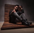 Side view of a seated fashion man in leather jacket Royalty Free Stock Photo