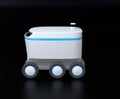 Side view of self-driving delivery robot on black background