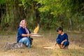 Side view of senior Asian woman work with winnow rice using basketry and little girl stay beside