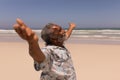 Senior black man with arms outstretched standing on beach Royalty Free Stock Photo